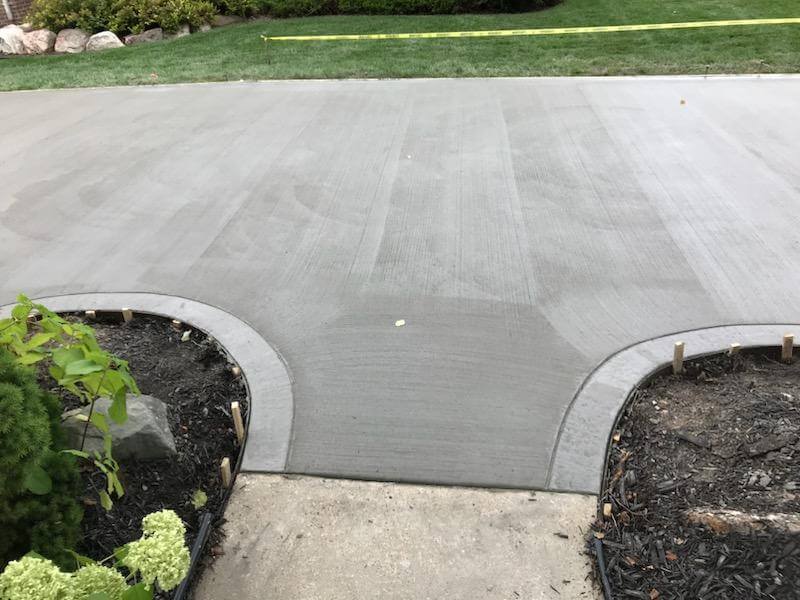 A sidewalk with a cement slab and concrete curbs.