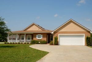 A house with a driveway and lawn in front of it.