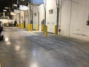 A warehouse with many yellow posts and concrete floors.