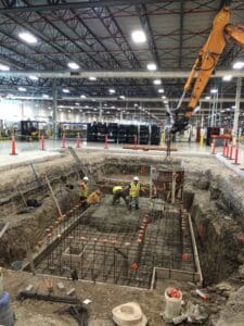 A large concrete slab being poured in an industrial building.