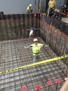 A man in yellow shirt standing on top of concrete.