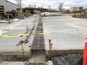 A concrete slab being poured for the sidewalk.