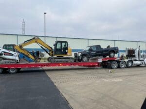 A truck is being towed by a tractor.