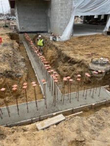 A worker is working on the foundation of a building.